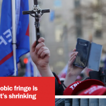 Photo from Brookings: Trump supporters wearing red Trump hats, one holds a crucifix