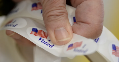 Photo from Brookings: hand holding  roll of "I voted" stickers