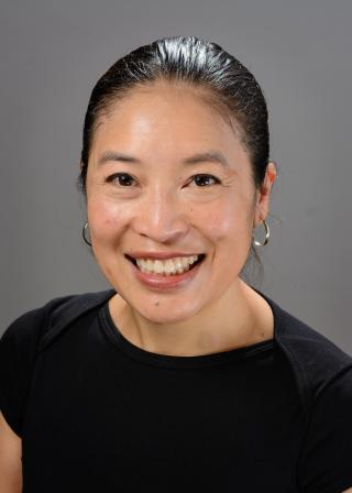 Photo of Janelle Wong (smiling in a black shirt, in front of a grey background)